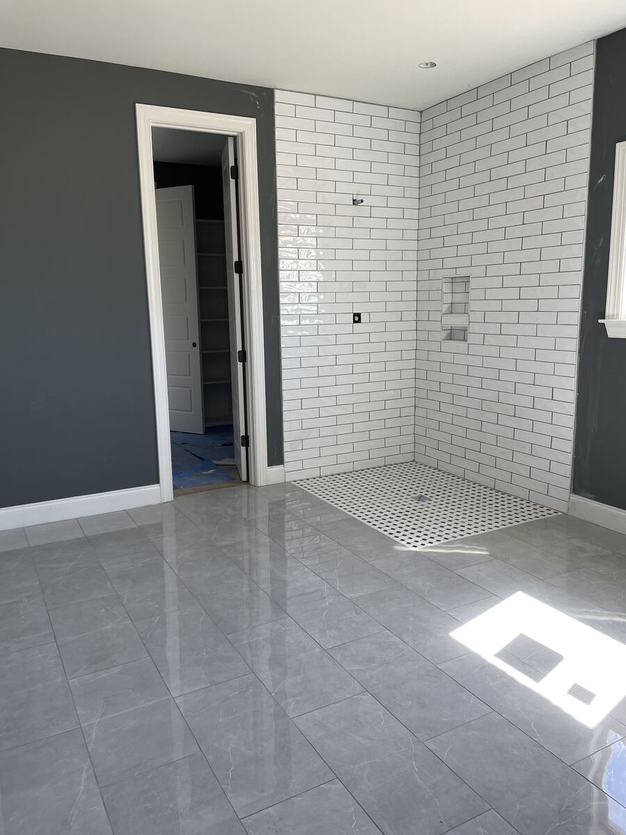 White subway tile shower with mosaic floor