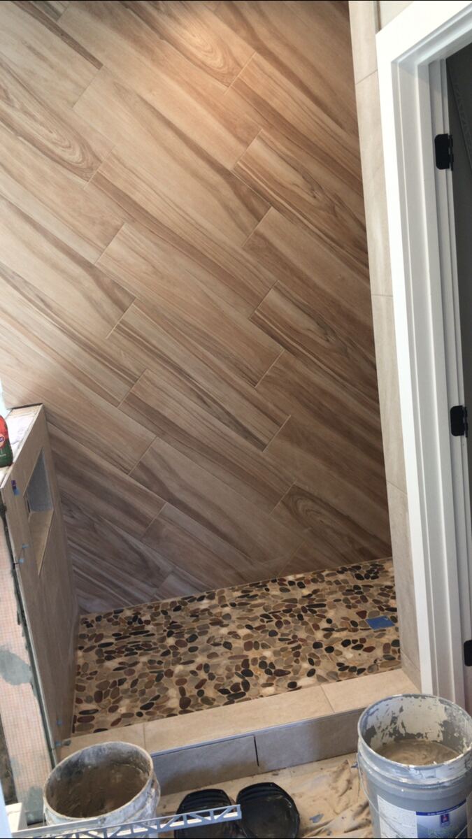 Wood-look tile shower with pebble floor