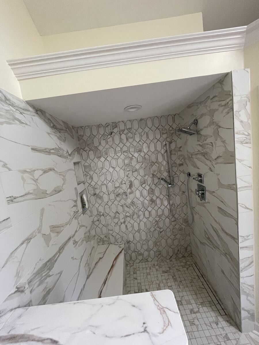 Marble hexagon tile shower with glass panel